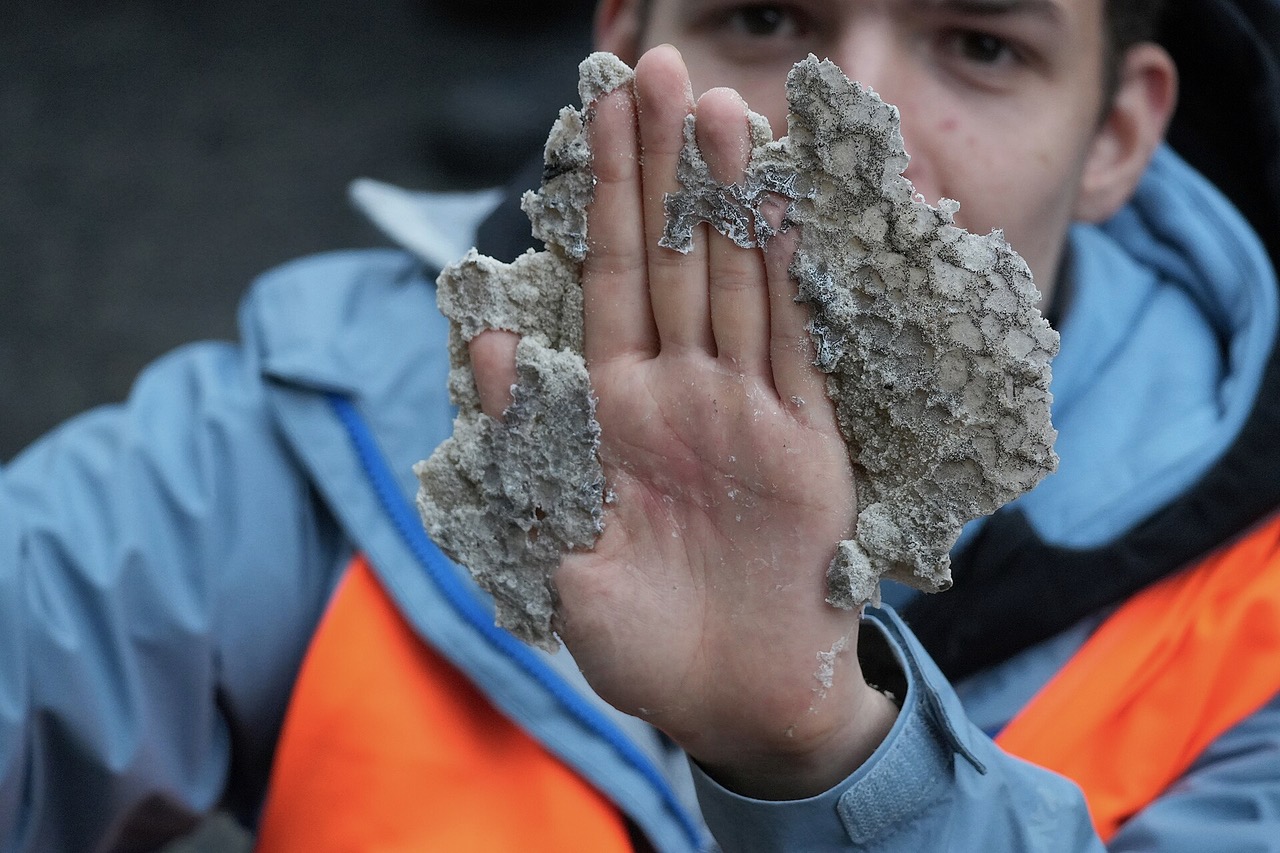 Young_letzte_generation_activist_with_hand_caked_in_cyanoacrylate_glue_and_sand.jpeg